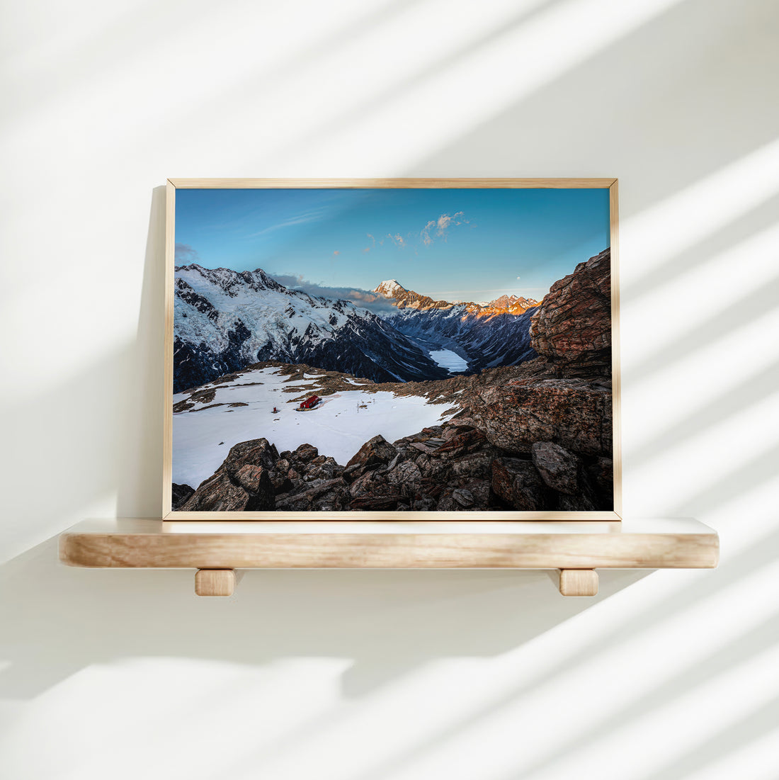 Mueller Hut Mount Cook National Park landscape photography print in natural wood frame on floating shelf against white wall with light shadows