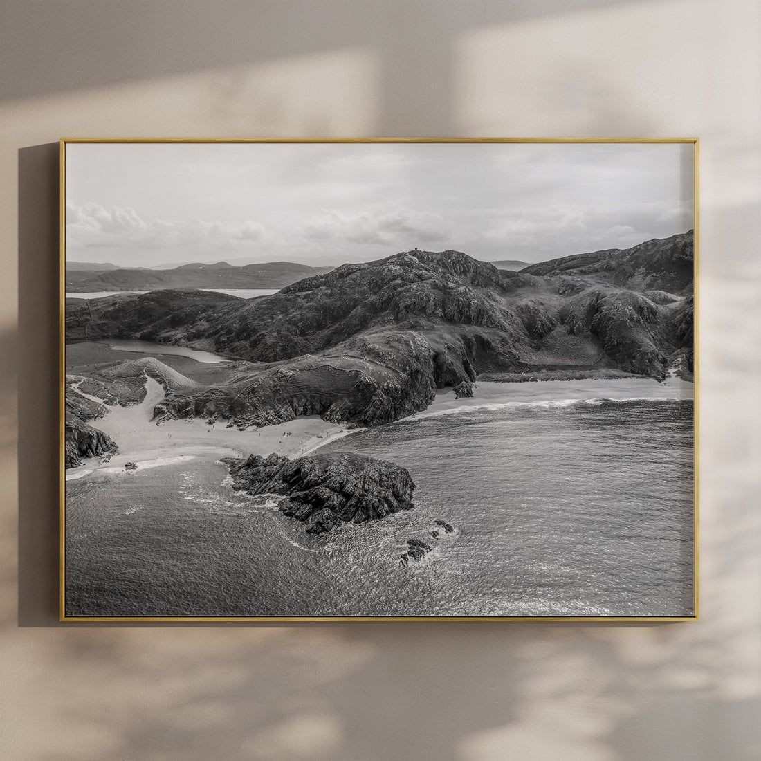 Black and white aerial print of Murder Hole Beach on a wall in soft shadow light.