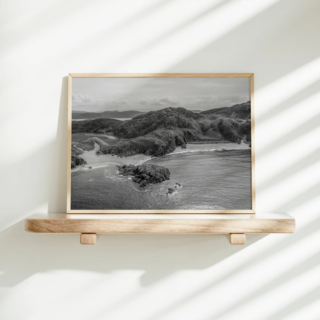 Aerial wall art of Murder Hole Beach in black and white on a clean white shelf with shadows.