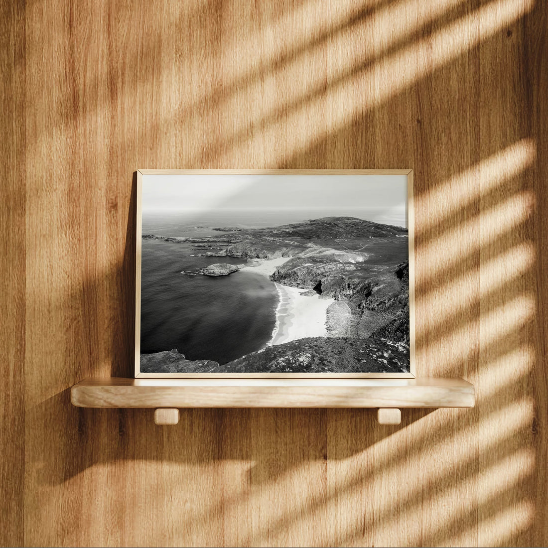Framed black and white photograph of Murder Hole Beach sitting on a wooden shelf.