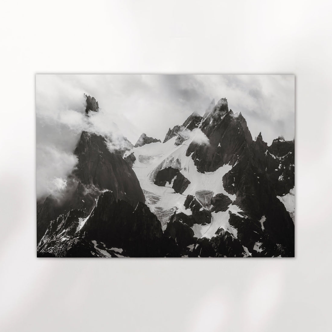 Fine art wall print of the iconic Needles of Chamonix in black and white with snowy glaciers and sharp rock spires.