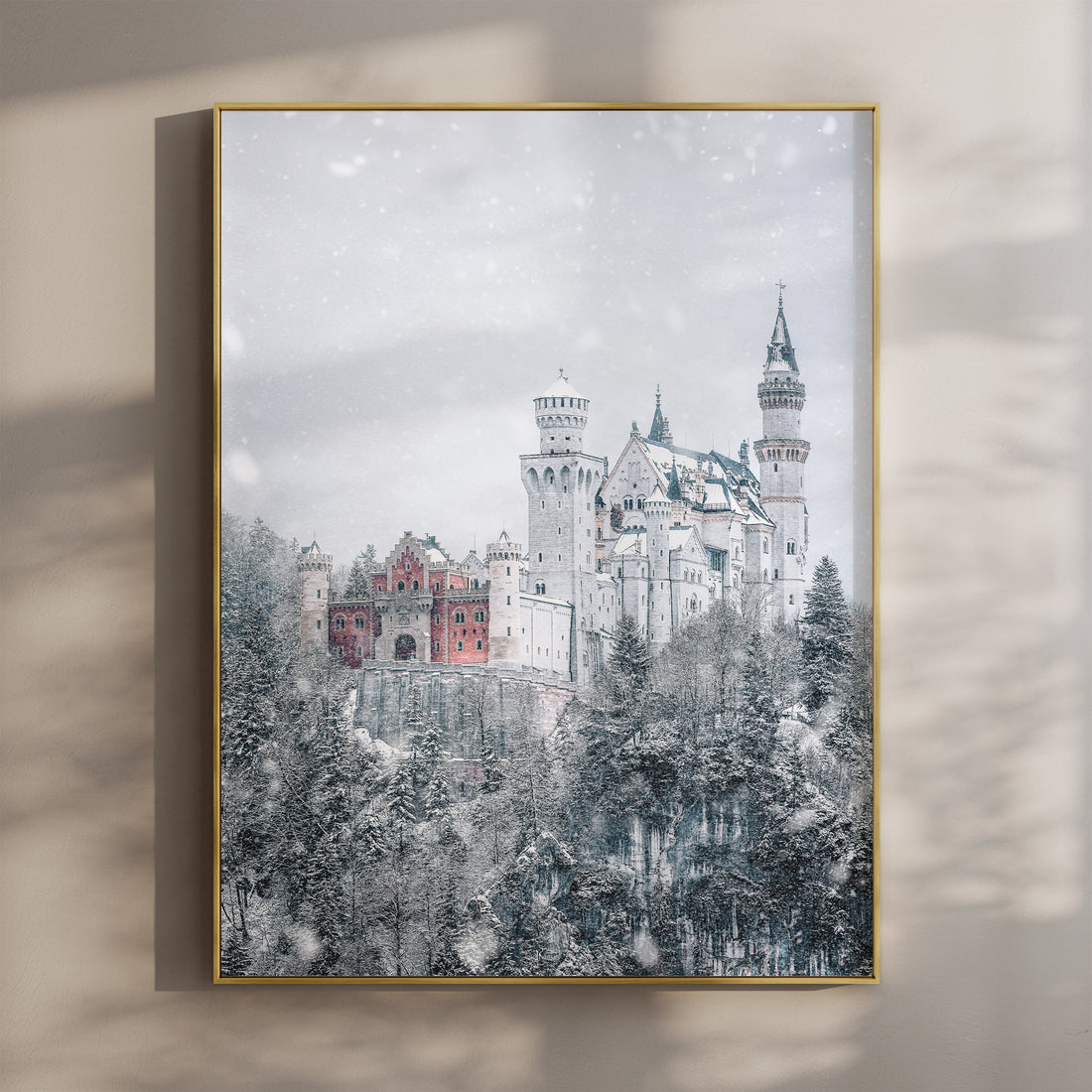 Snow-covered Neuschwanstein Castle print in gold frame on neutral wall