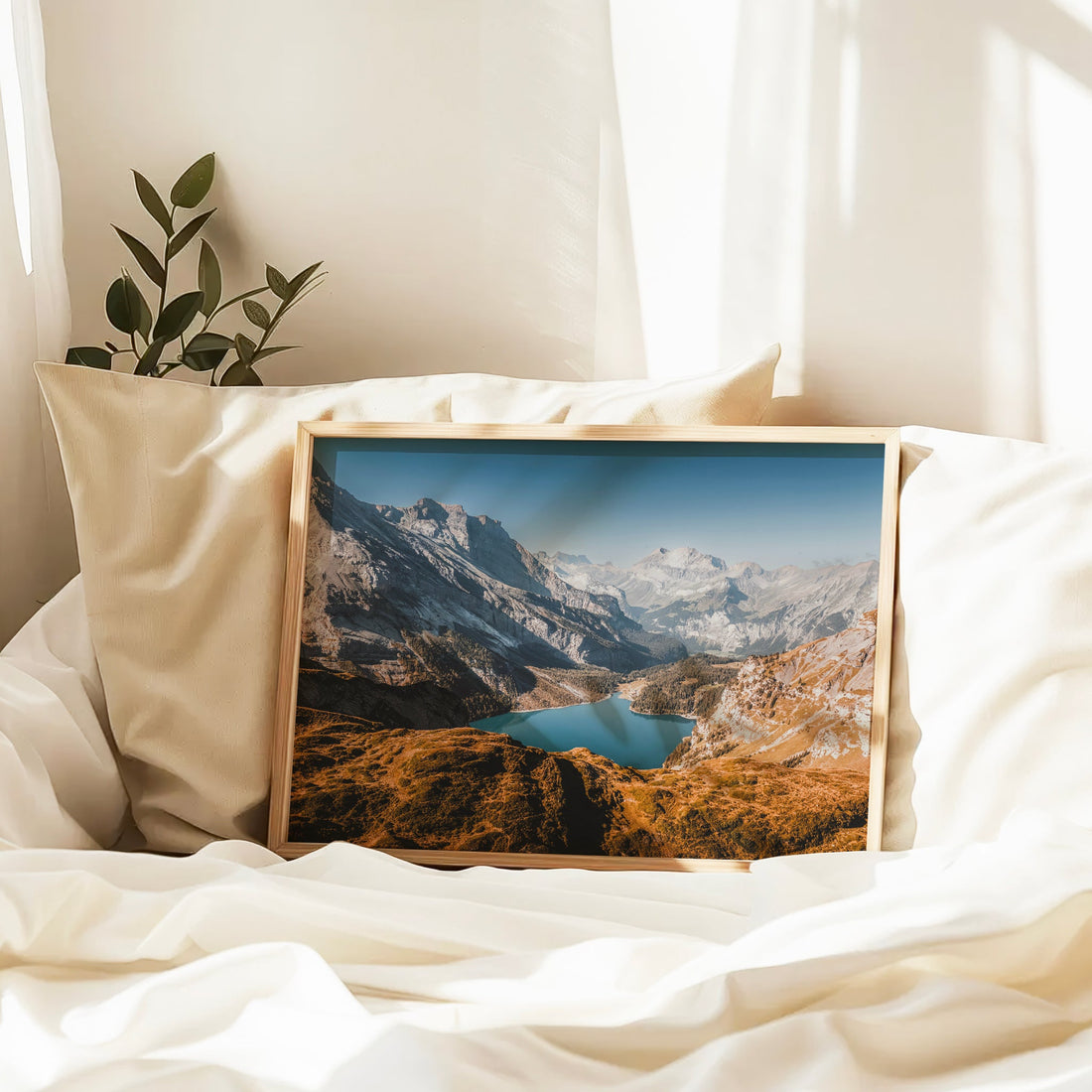 Framed landscape print of Lake Oeschinen on white bedding