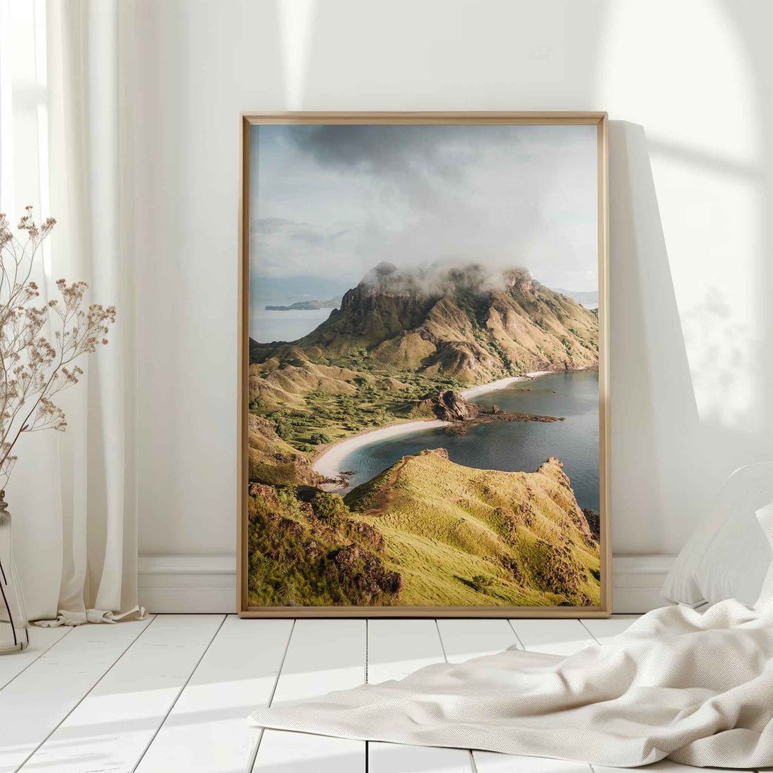 Padar Island Komodo National Park large framed wall art print in natural wood frame leaning against white wall with dried flowers