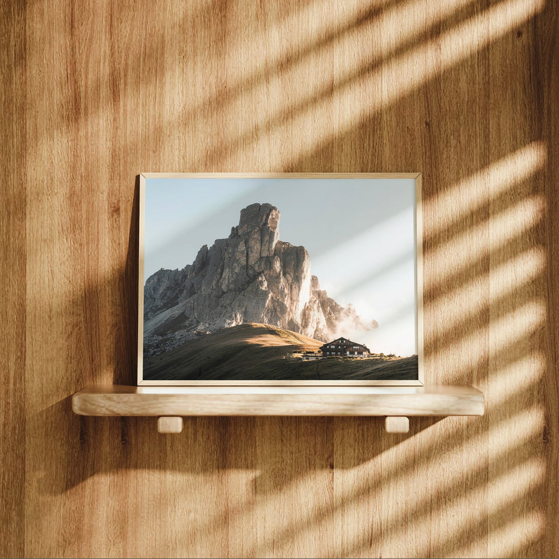 Passo Giau landscape print on a wooden shelf with dappled light and shadows