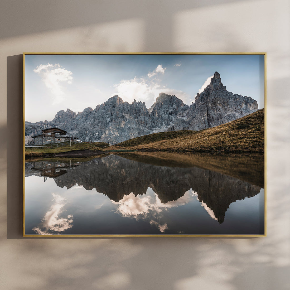 Framed landscape print of Passo Rolle at sunset with mountain reflection on wall
