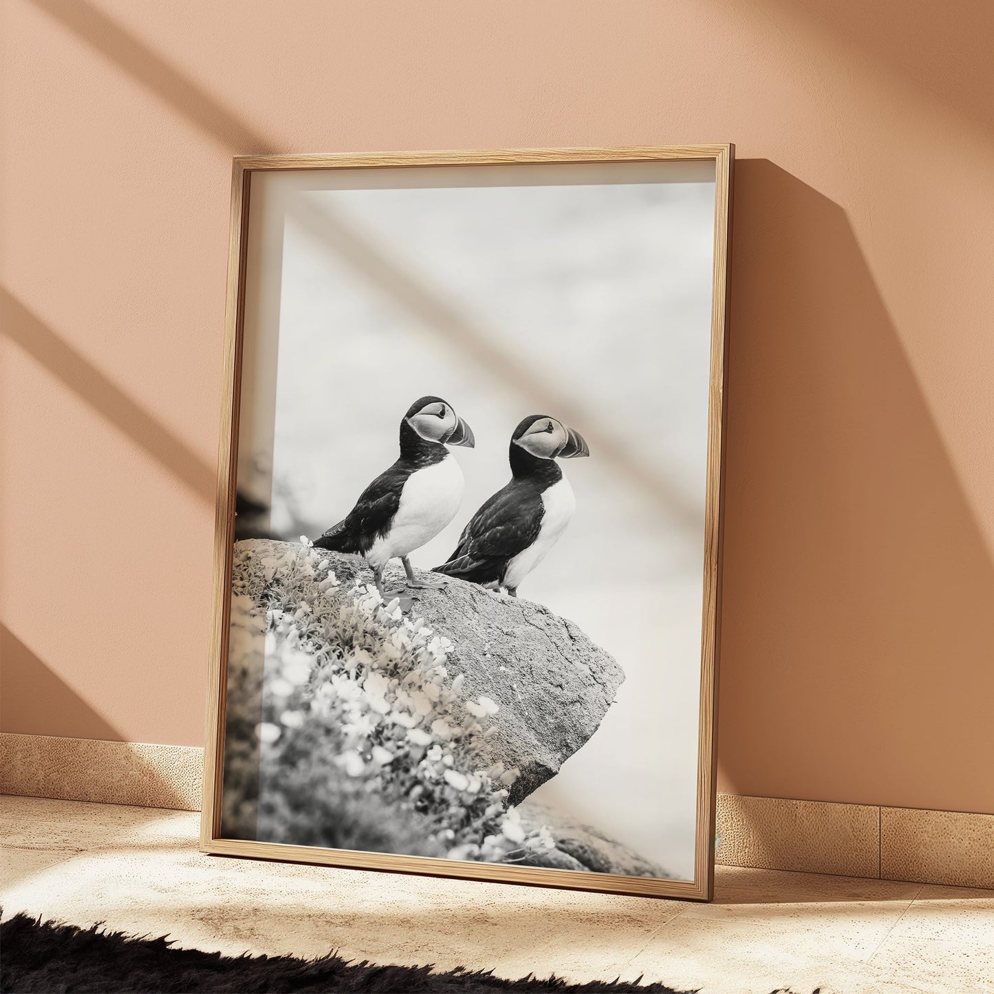 Two puffins on a cliffside in a black and white photo print.
