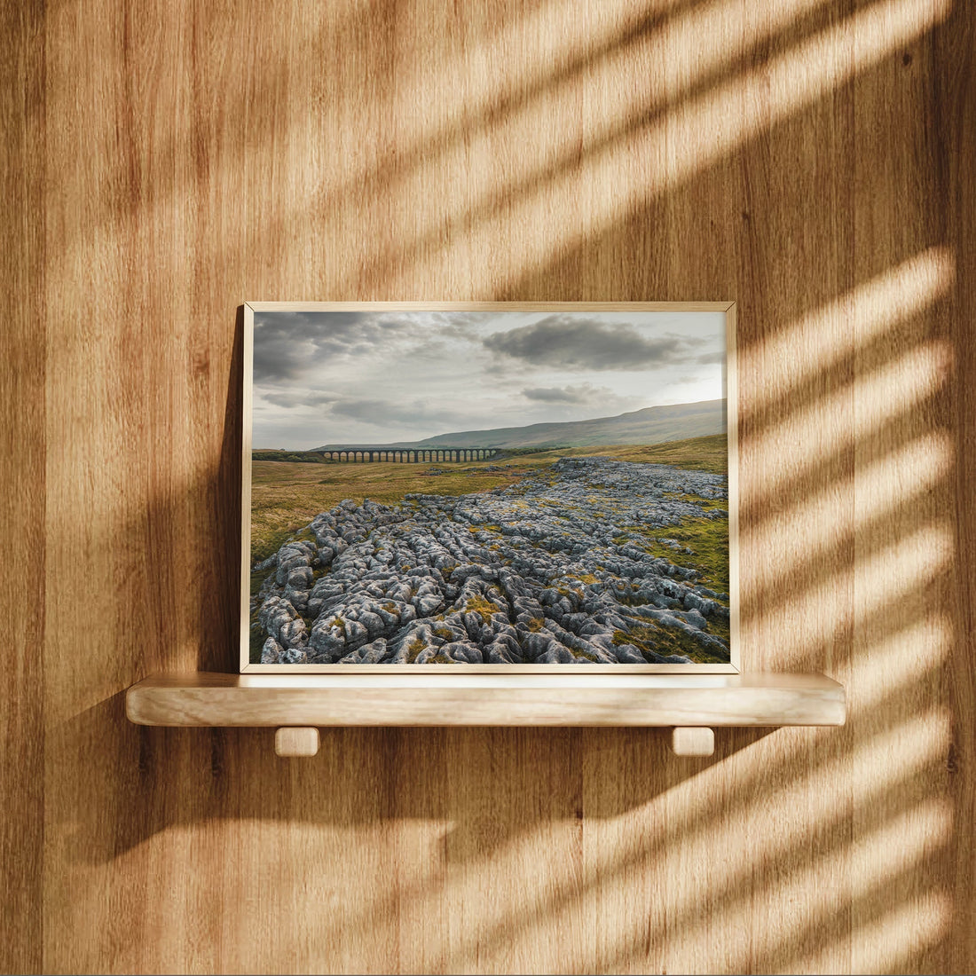 Ribblehead Viaduct photography print resting on a wooden shelf