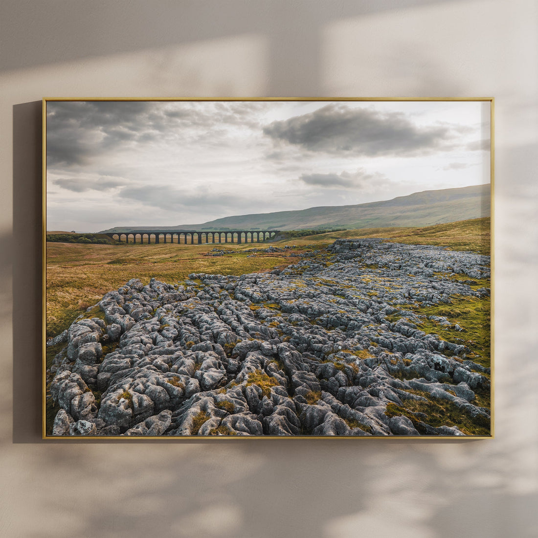 Ribblehead Viaduct at golden hour with limestone pavement and dramatic sky