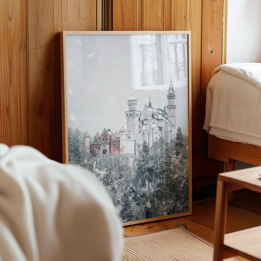 Framed Neuschwanstein Castle print resting against wooden wall in bedroom
