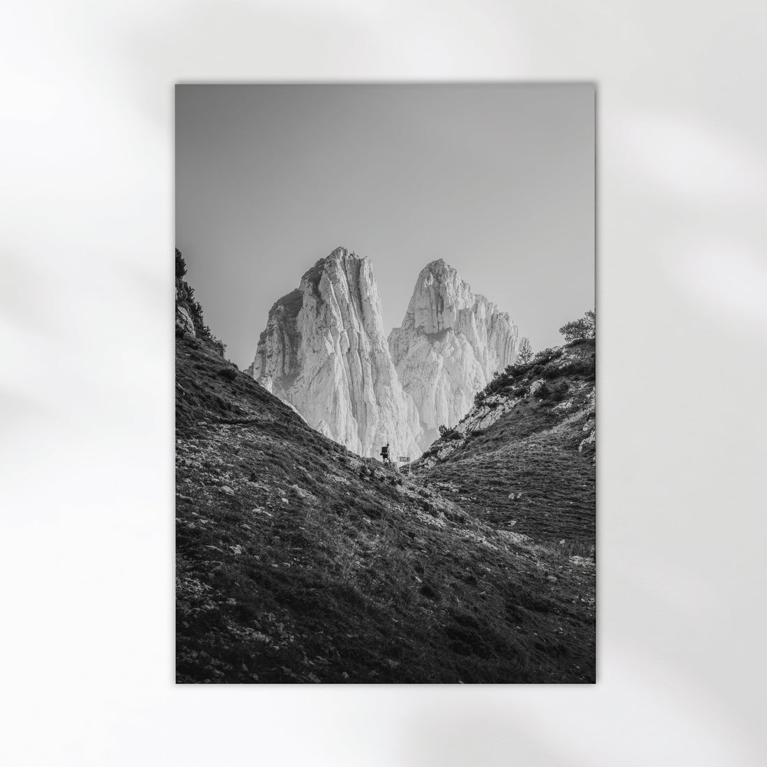 Close-up of black and white Saxer Lücke wall art print with hiker between two peaks