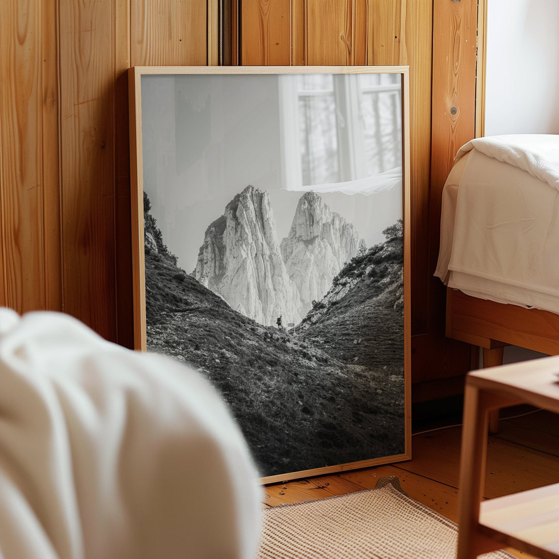 Black and white Swiss Alps print with hiker leaning against a bedroom wall