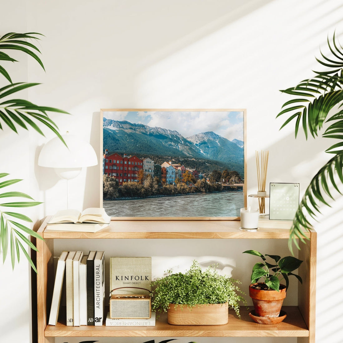 Innsbruck art print styled on desk with alpine light and home decor elements.