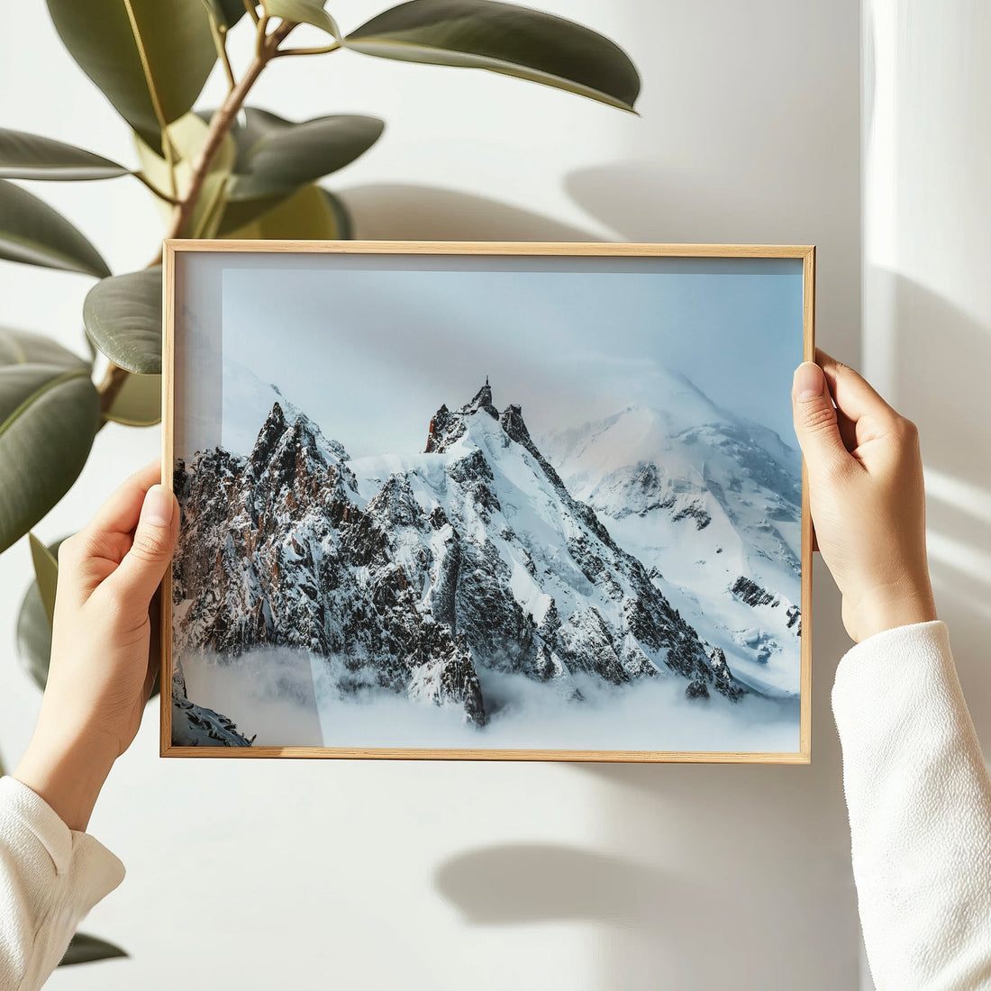 Aiguille du Midi mountain print held in hands with plant in background