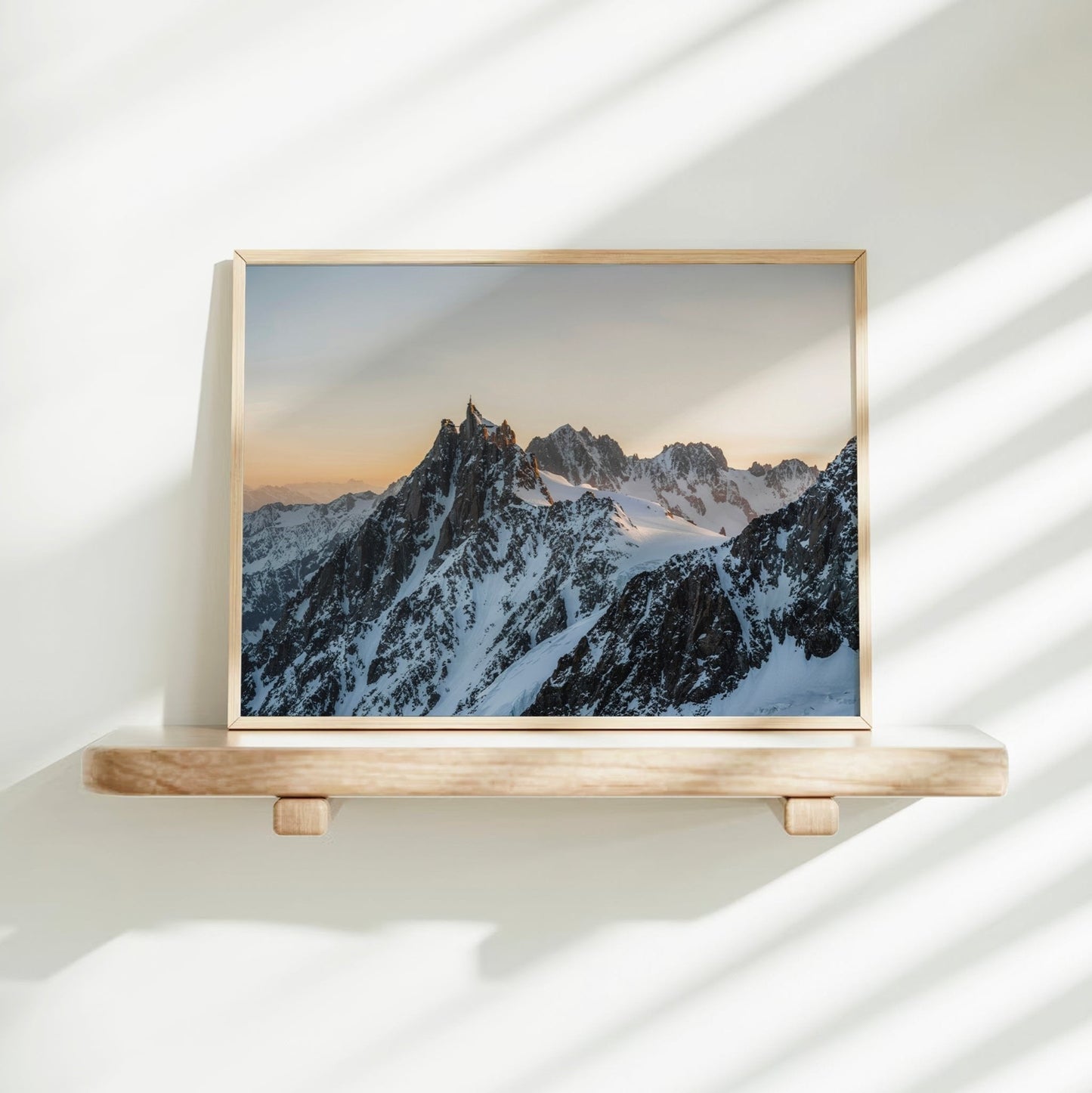 Striking photograph of Aiguille du Midi with soft golden light and glacial slopes in the French Alps.