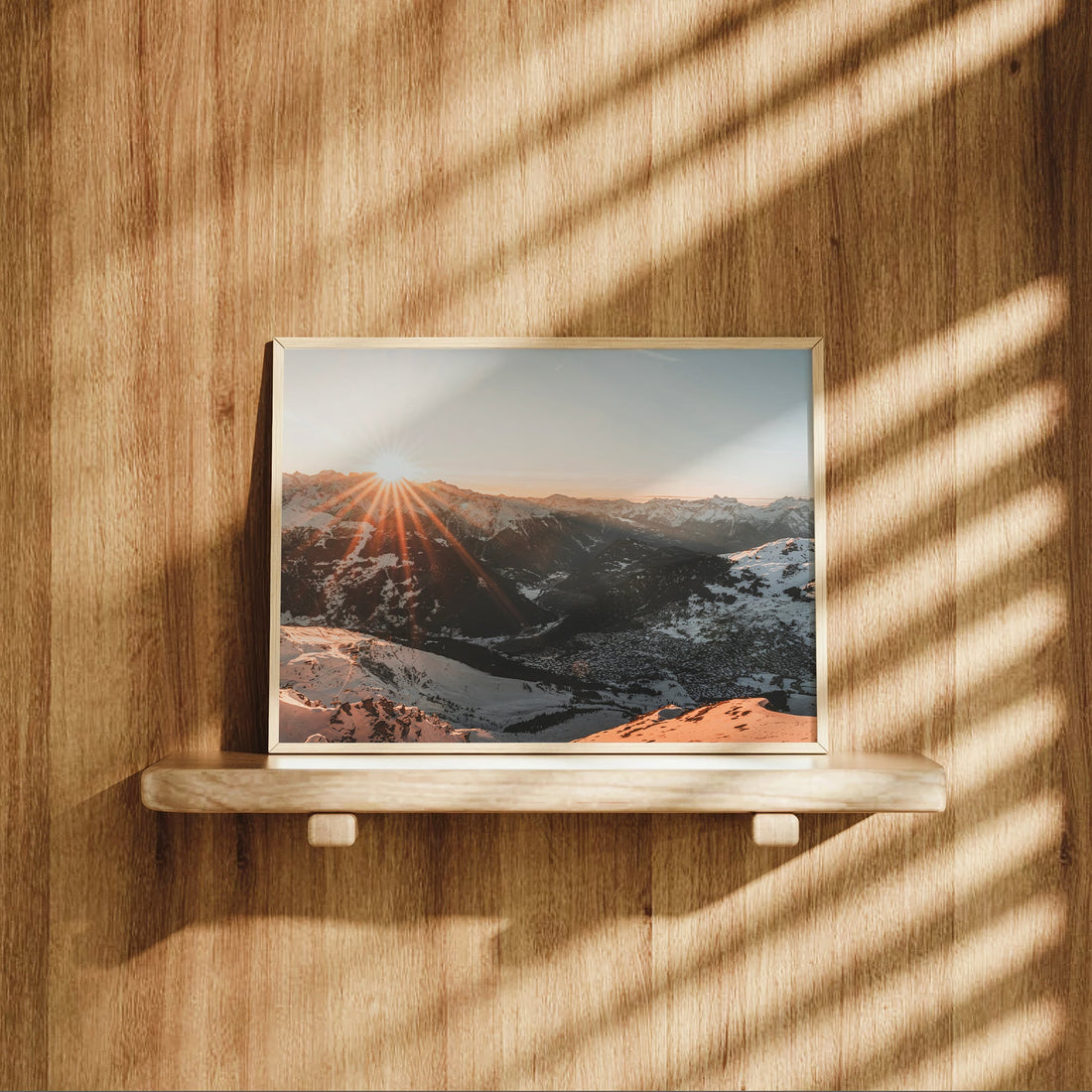 Breathtaking sunrise over Verbier valley with long sun rays beaming across snow-covered mountaintops.