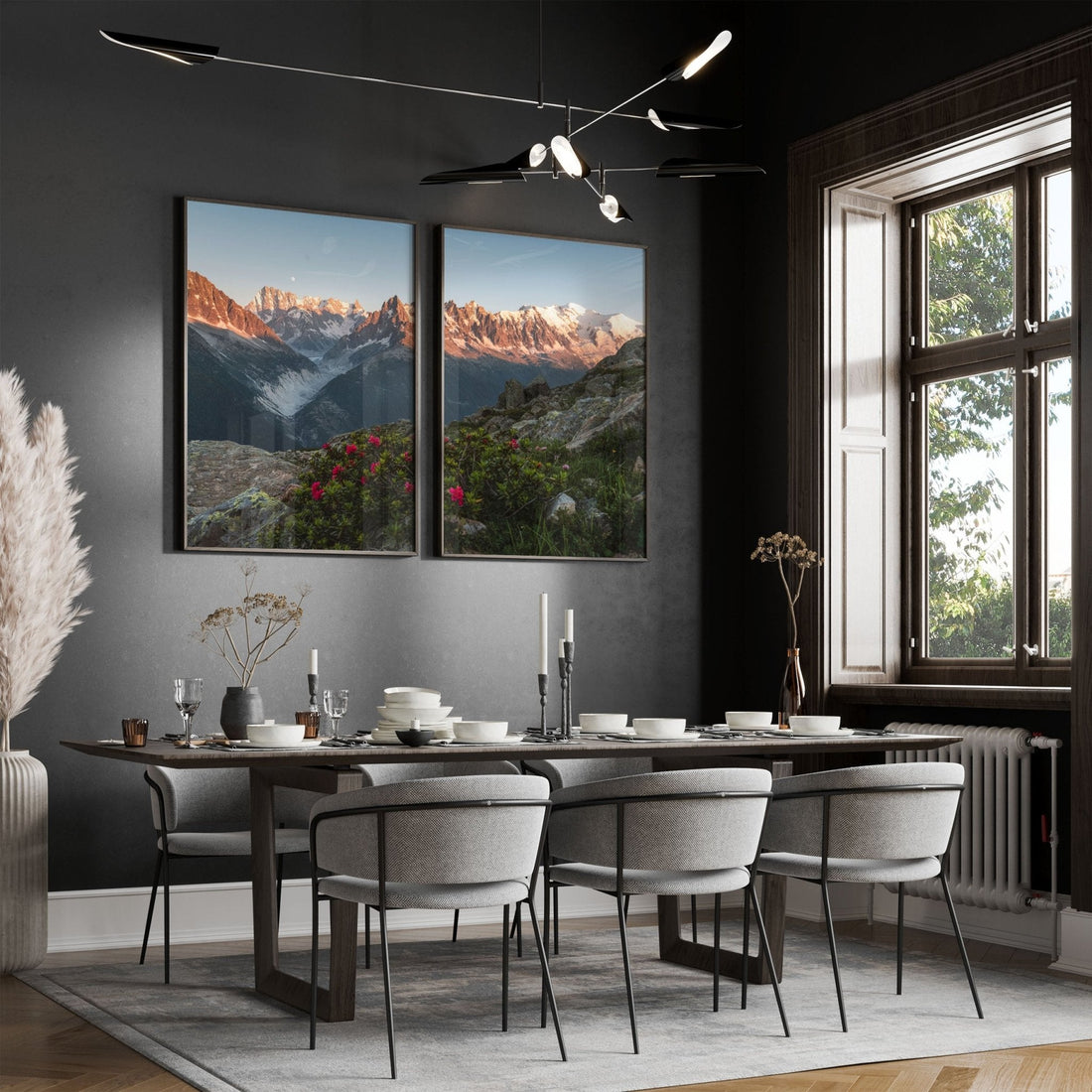 Dining room setup featuring wall-mounted framed prints of sunset mountain scenes, highlighted by wildflowers and alpine peaks.