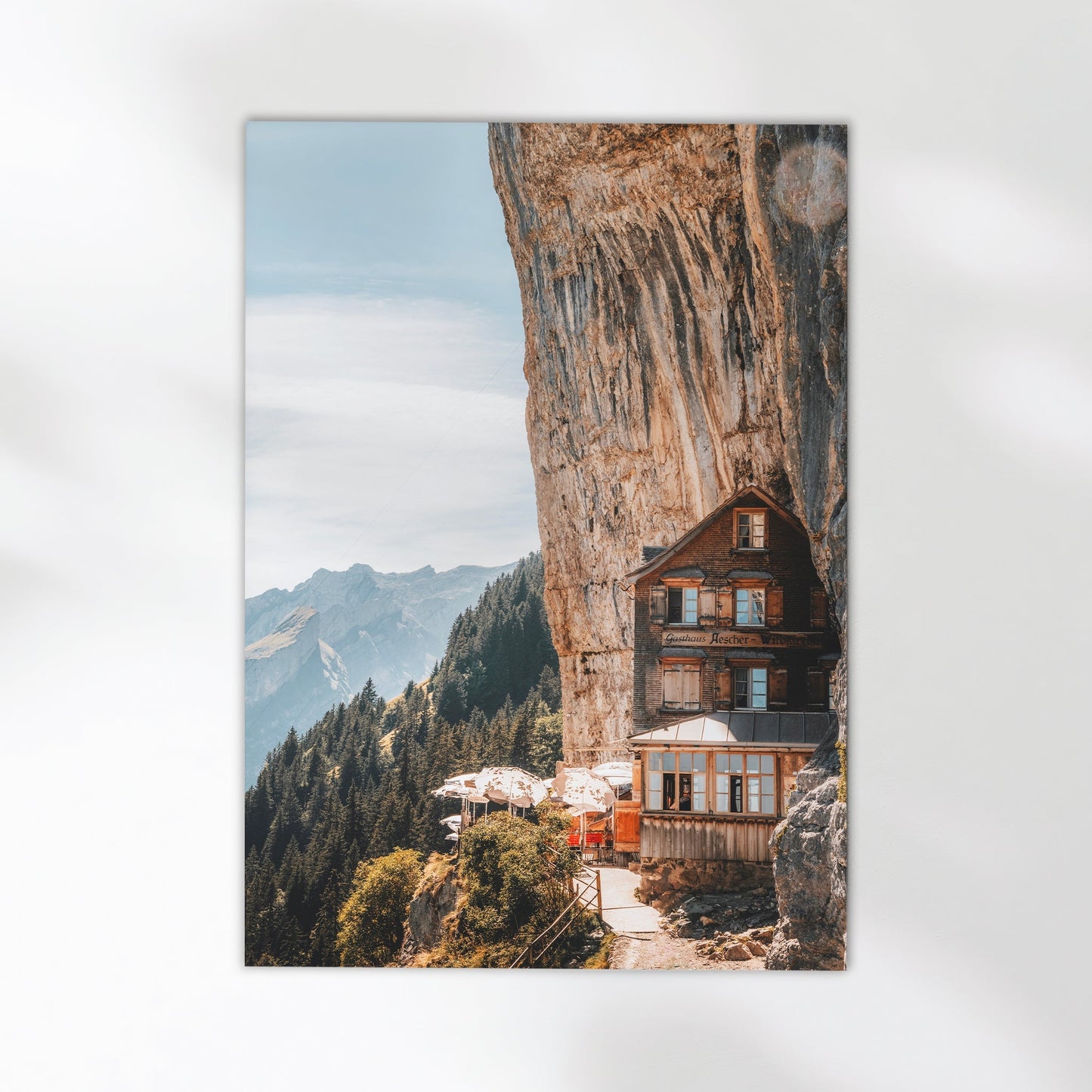 Stunning Swiss Alps cliffside hotel, the famous Aescher Guesthouse nestled against a dramatic rock face.