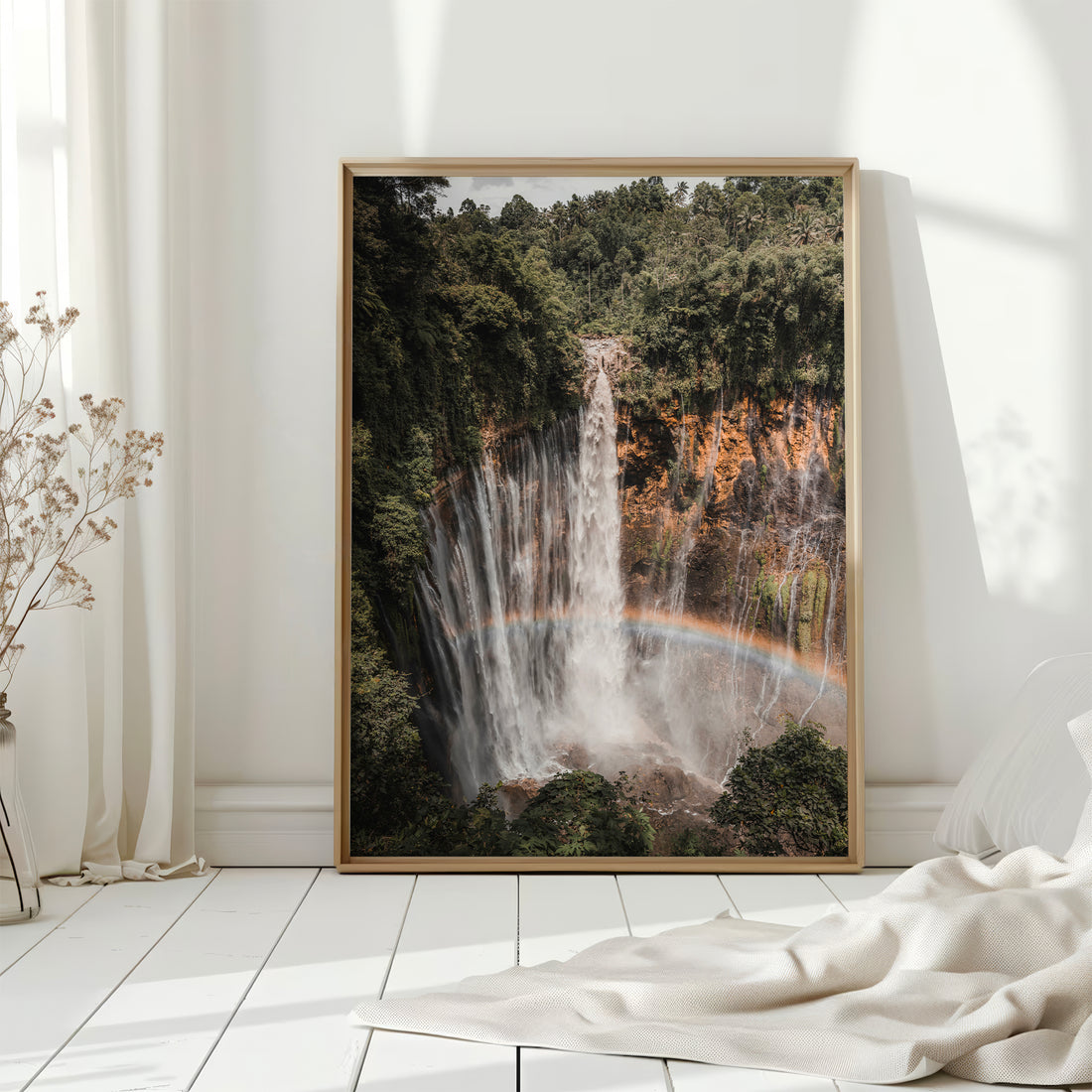 Tumpak Sewu Waterfall wall art print displayed on a wooden table with decor