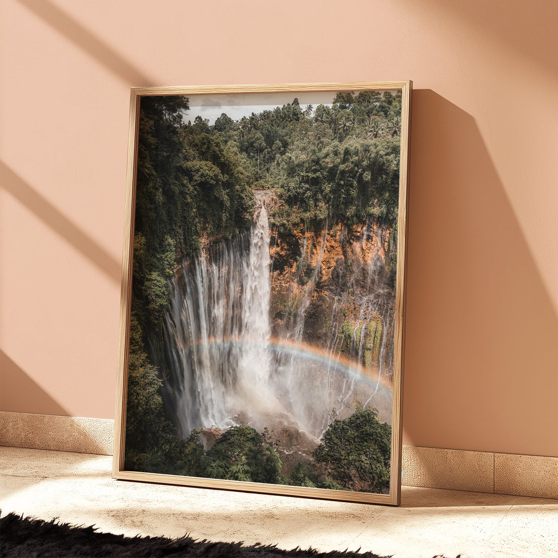 Tumpak Sewu Waterfall wall art print leaning against a wall in a cozy interior