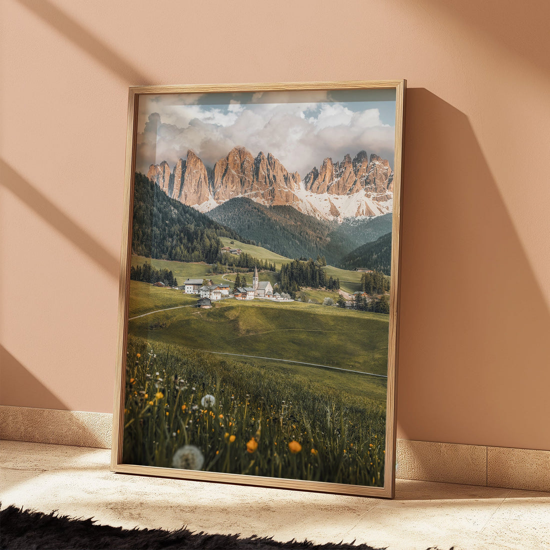 Framed Dolomites photo leaning against peach-coloured wall in warm light