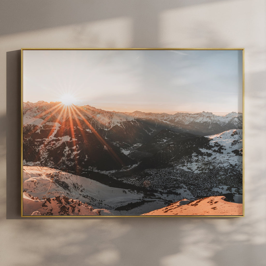 Wide Verbier sunrise print with sun rays bursting over snowy peaks and alpine villages in golden light.