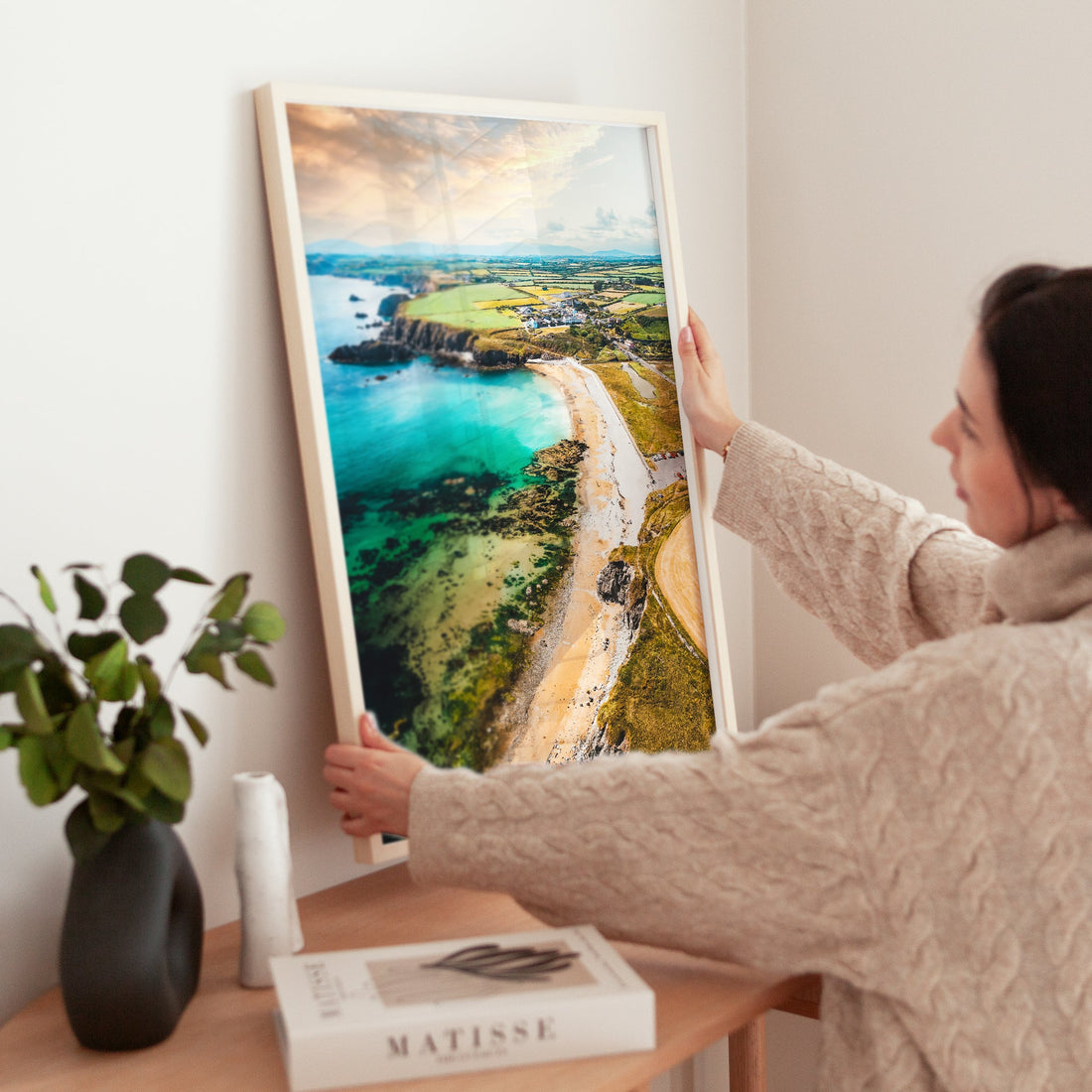 Woman placing an Annestown Beach art print on a wooden desk