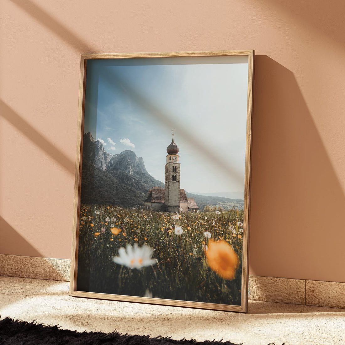 Soft light falling on framed San Valentino church print in an earthy-toned room