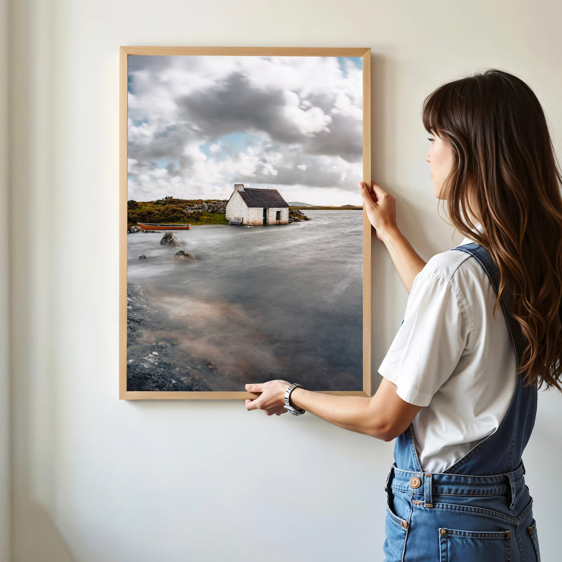 Woman hanging Connemara bothy coastal print on wall