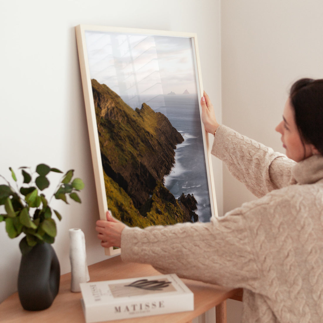 Woman holding framed landscape print of Kerry cliffs in Ireland