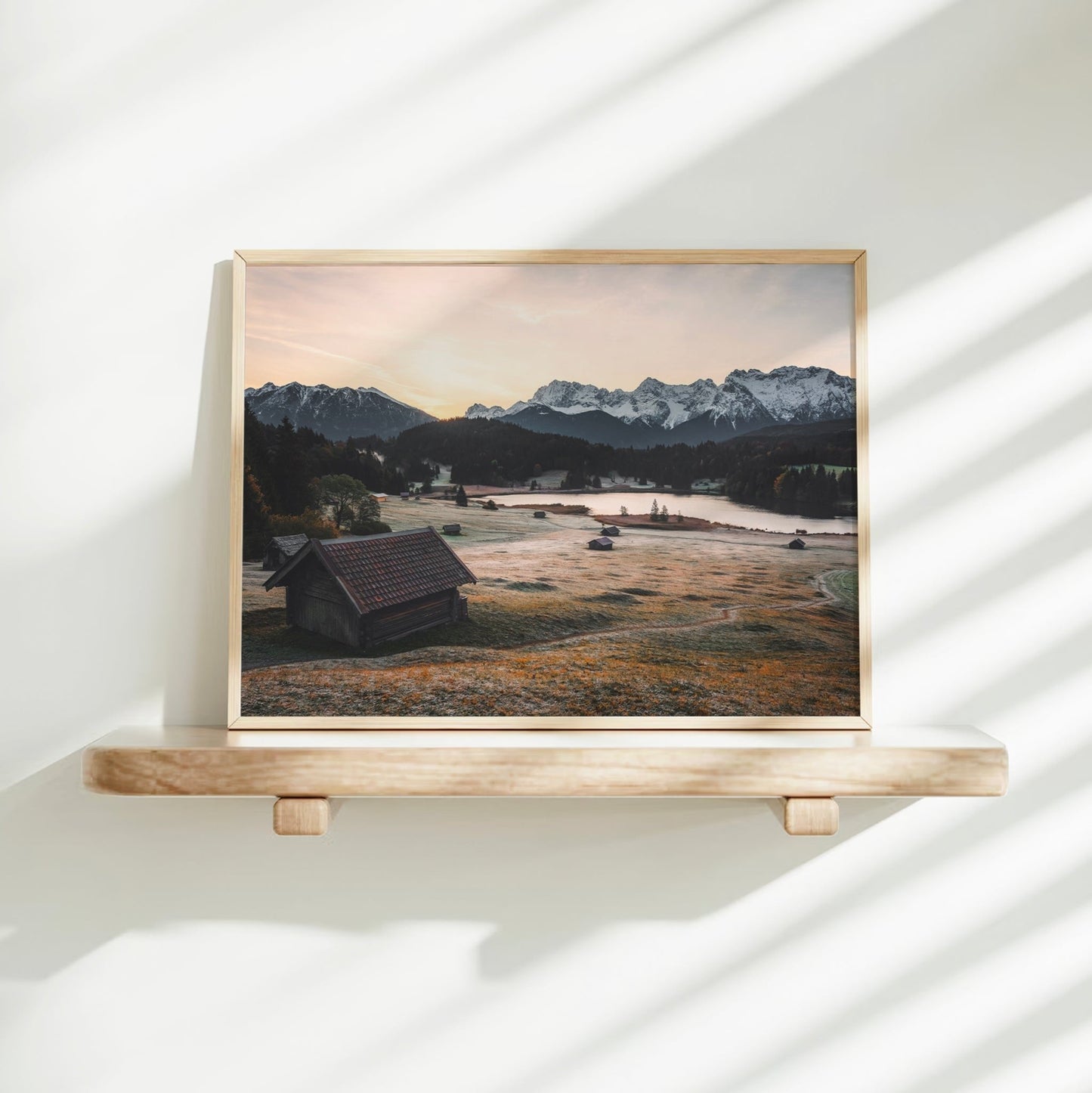 Woman placing a fine art Geroldsee print in a bright modern interior