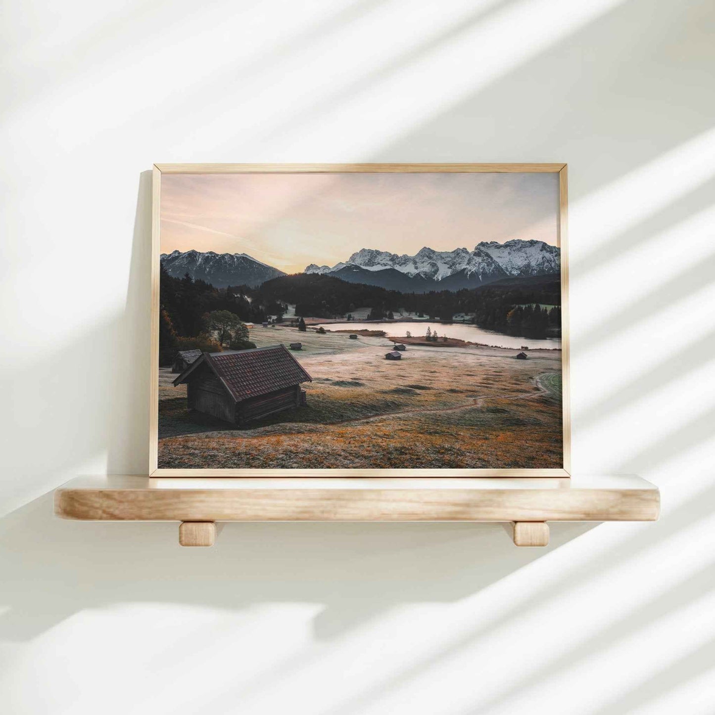 Woman placing a fine art Geroldsee print in a bright modern interior
