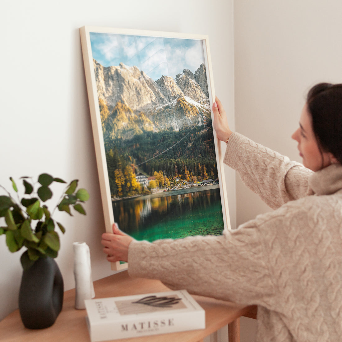 Woman styling home interior with Eibsee Bavaria nature photography print