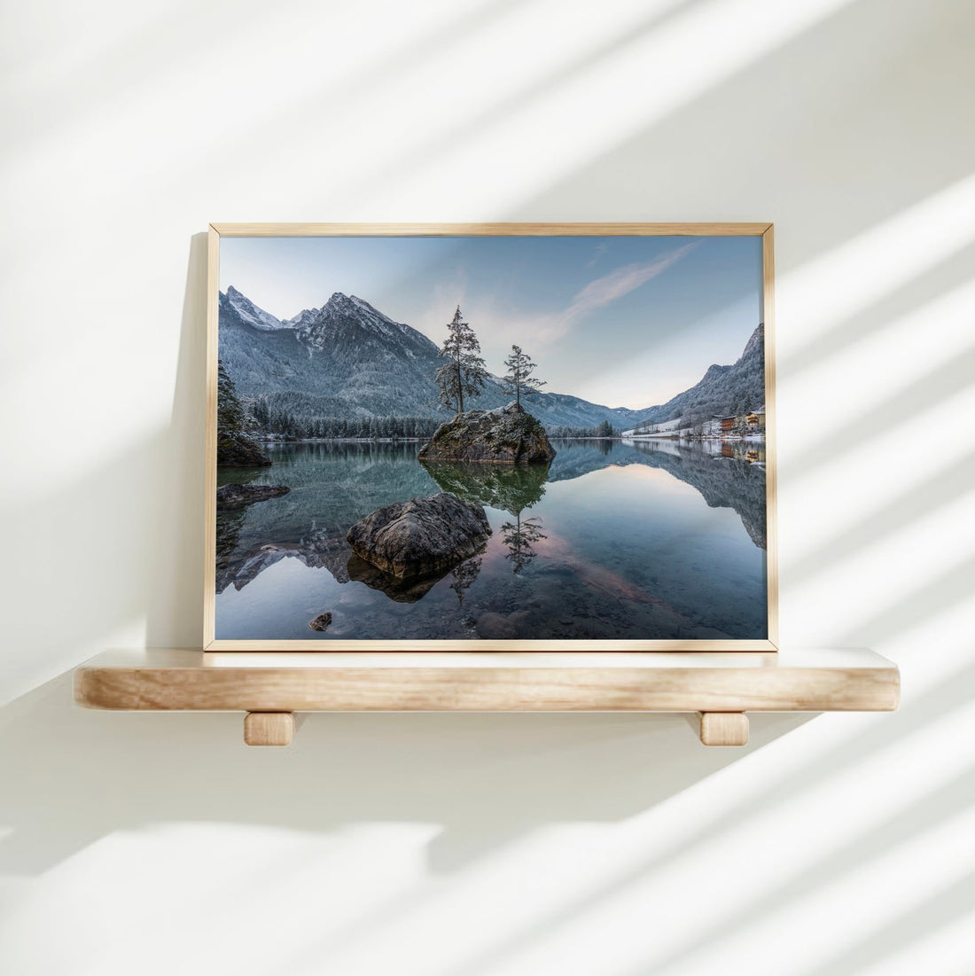 Woman placing a framed Hintersee sunrise landscape print on a shelf