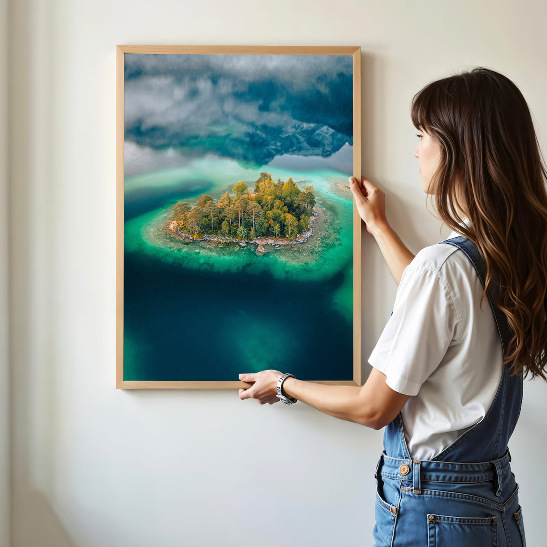 Woman hanging Eibsee island print with deep green water and forest tones