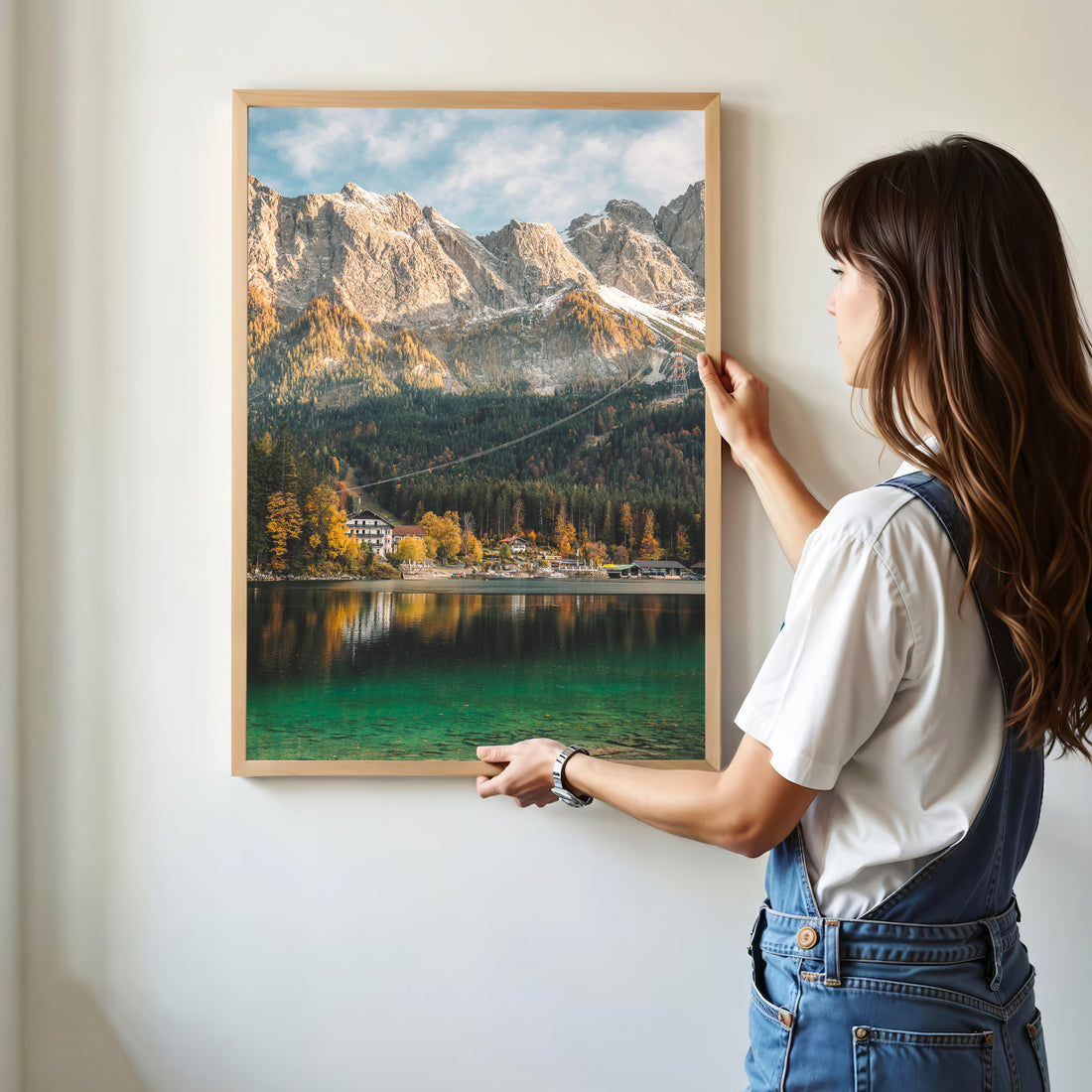 Woman hanging Eibsee wall print featuring alpine lake and autumn colours