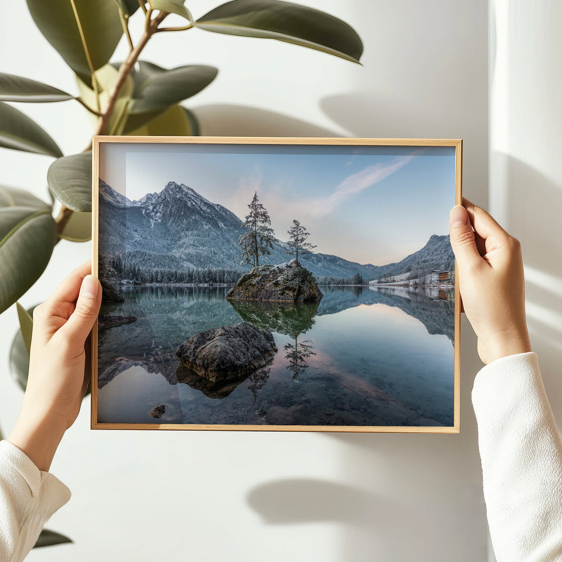 Woman hanging a sunrise print of Hintersee lake with alpine reflections