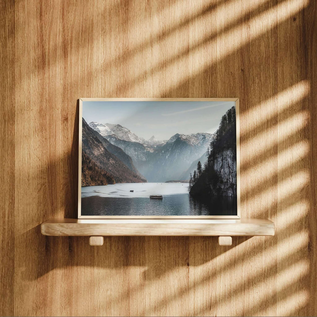 Königssee wall art displayed on wood shelf with natural light shadows