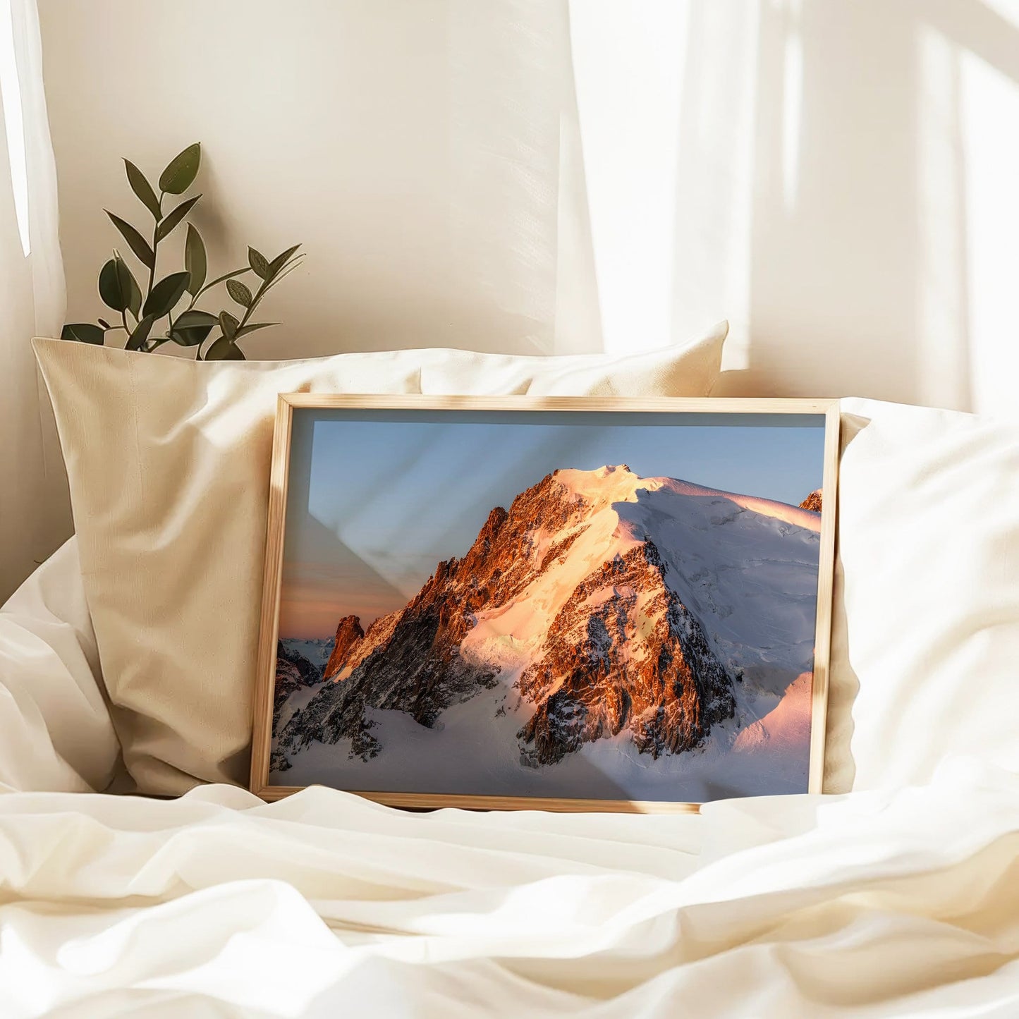 Framed Mont Blanc du Tacul print displayed in a bedroom flat-lay on white bedding