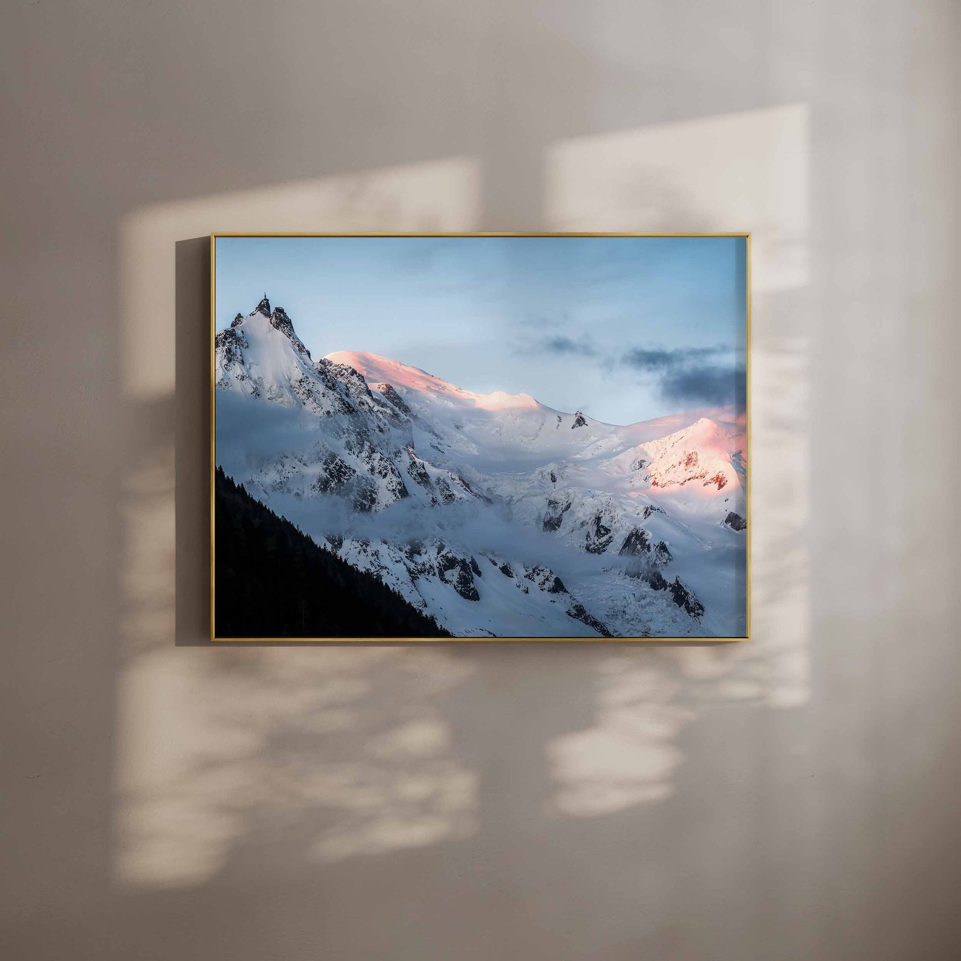 Framed wall art print of the Aiguille du Midi with alpenglow on the snowy peaks, styled with soft shadows.