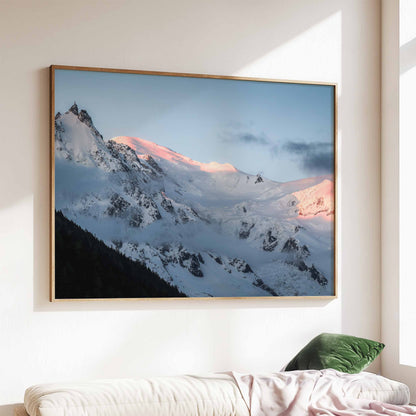 Aiguille du Midi mountain print capturing the soft pink glow of sunrise, elegantly framed above a cozy sofa.