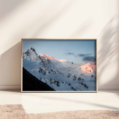 Large framed print of the Aiguille du Midi with pink sunrise light, styled on a minimalist floor setting.