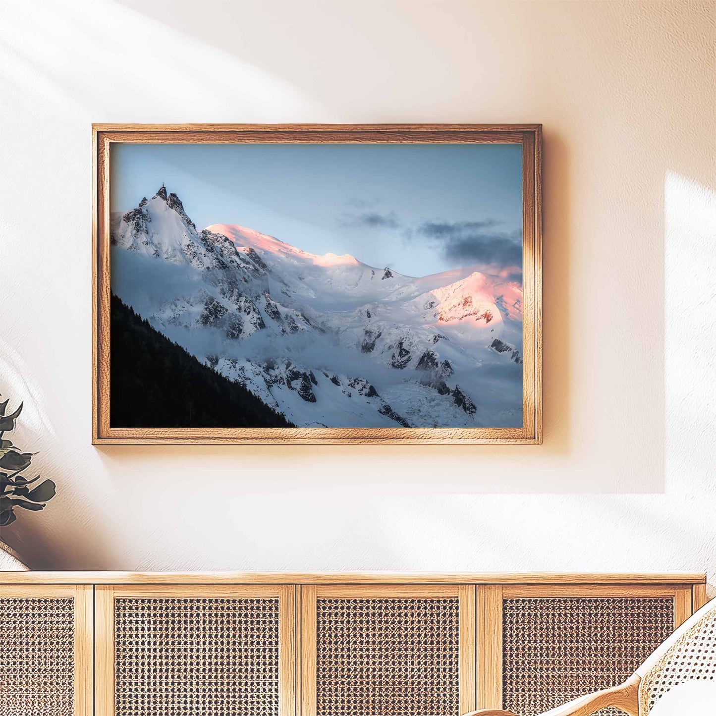 Rustic framed wall art of the Aiguille du Midi with glowing snowy peaks at sunrise, styled above a wooden sideboard.