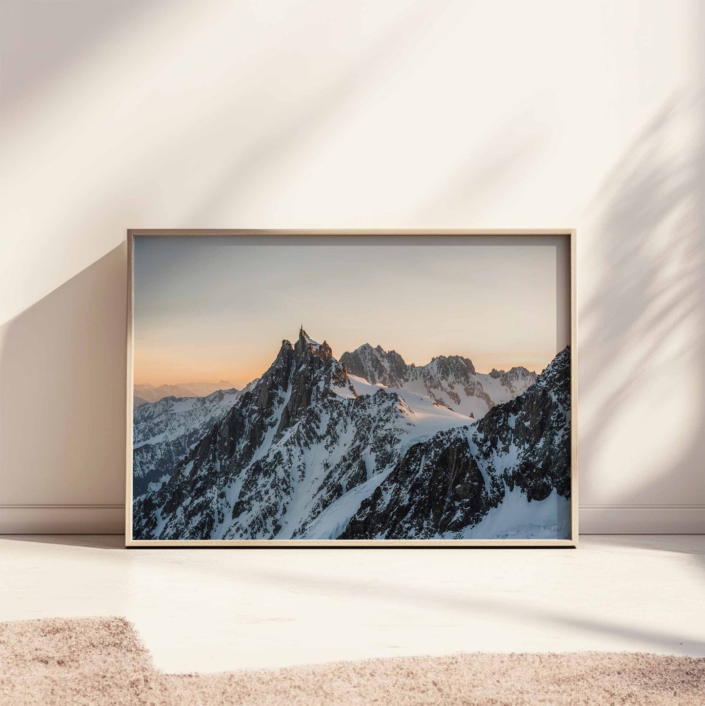 Large framed sunset print of the Aiguille du Midi, styled on a sunlit floor.