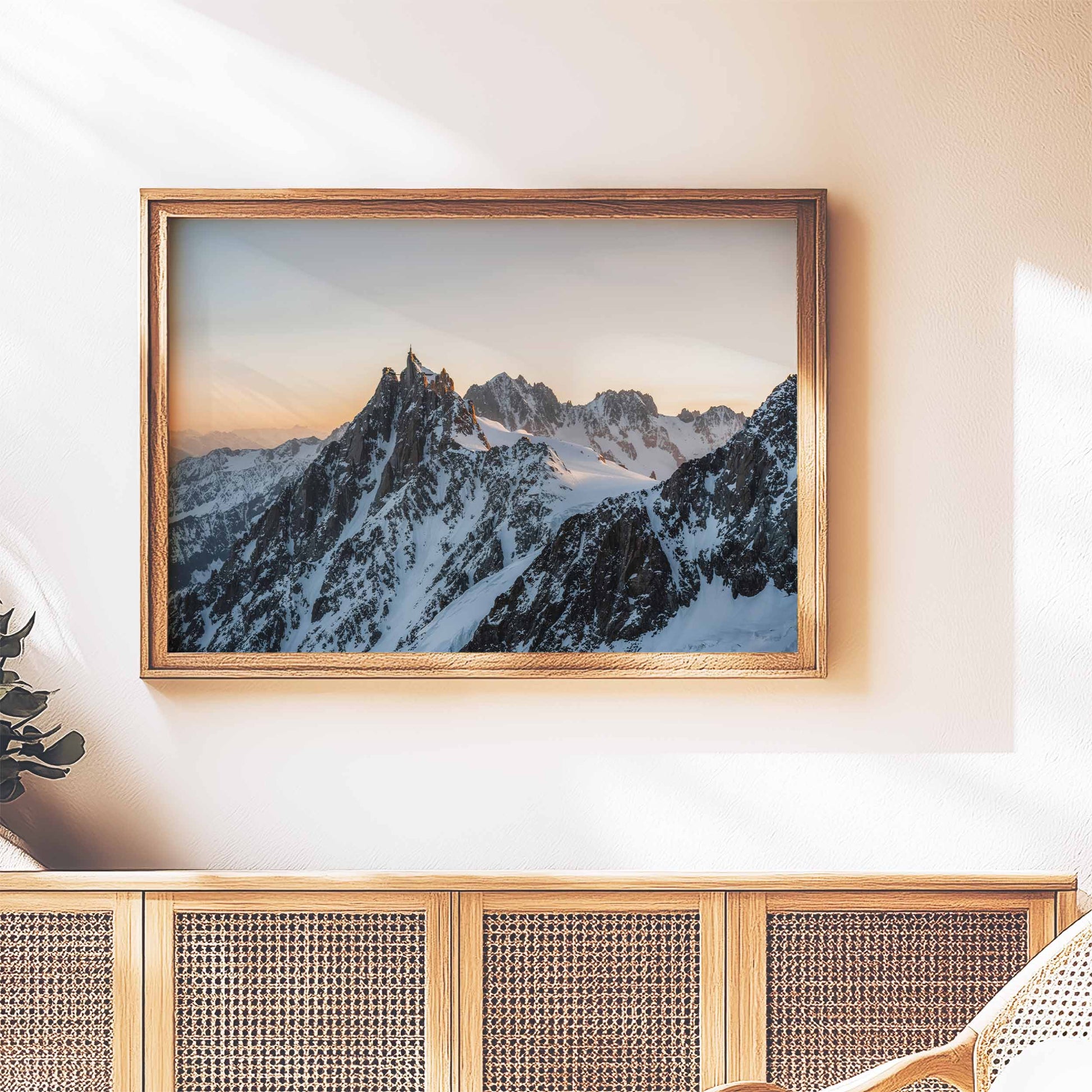 Rustic framed Chamonix wall art of the Aiguille du Midi at sunset, styled above a wooden sideboard.