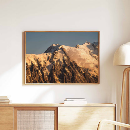 A stunning sunset print of the Aiguille du Midi, framed and styled on a wooden cabinet.