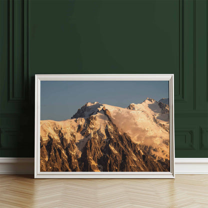 Golden hour wall art of the Aiguille du Midi, framed and leaning against a dark green wall for contrast.