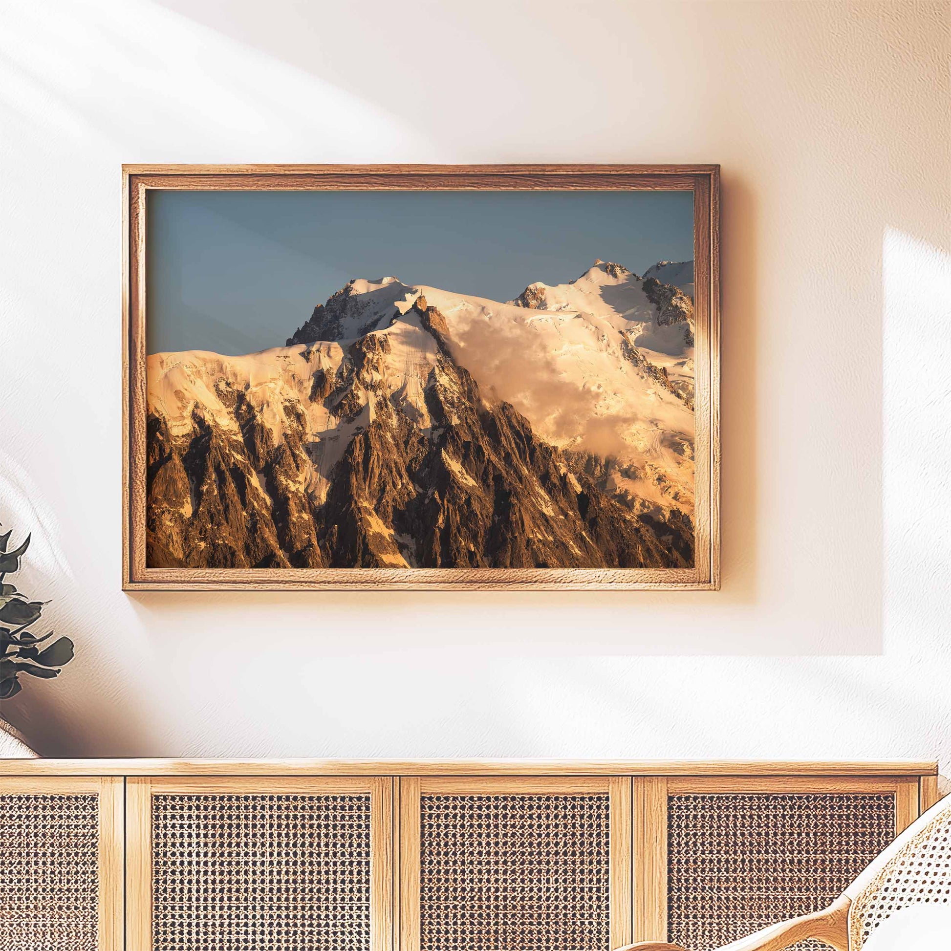 Rustic framed wall art of the Aiguille du Midi glowing at sunset, styled above a wooden sideboard.