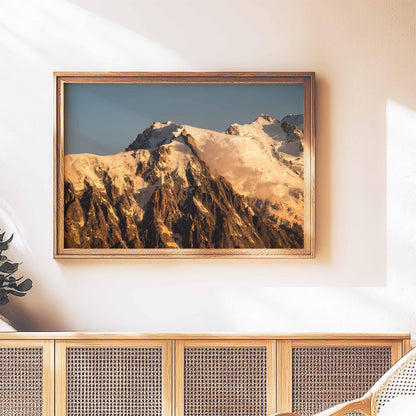 Rustic framed wall art of the Aiguille du Midi glowing at sunset, styled above a wooden sideboard.