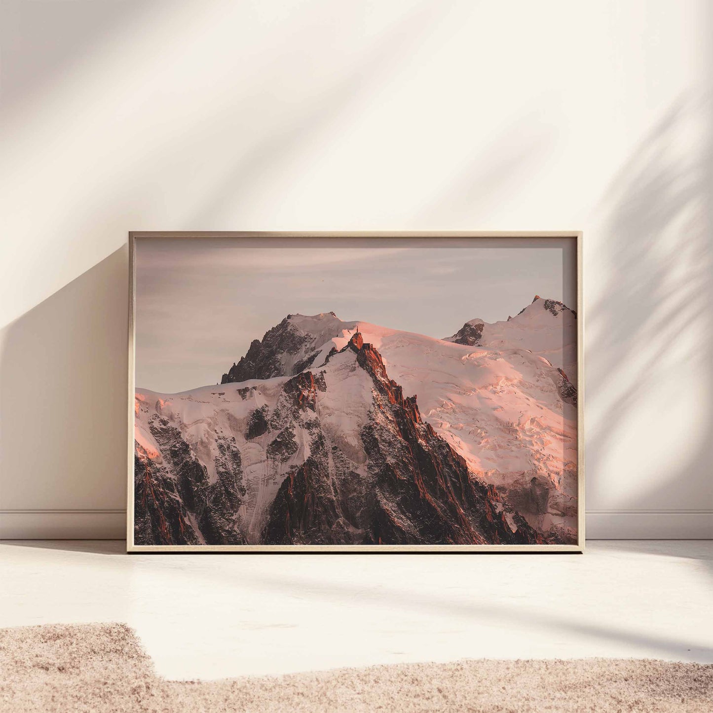 Framed Chamonix print of the Aiguille du Midi in the evening sun, styled on a sunlit floor.